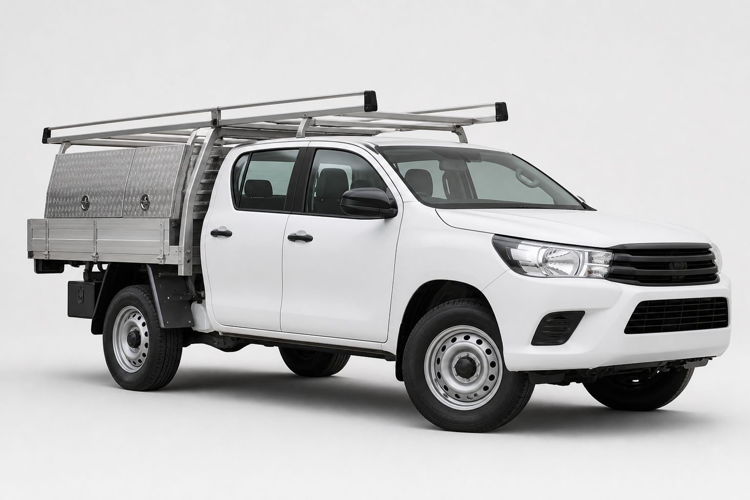 White dual-cab trade ute fitted with aluminium tray, toolboxes and ladder rack